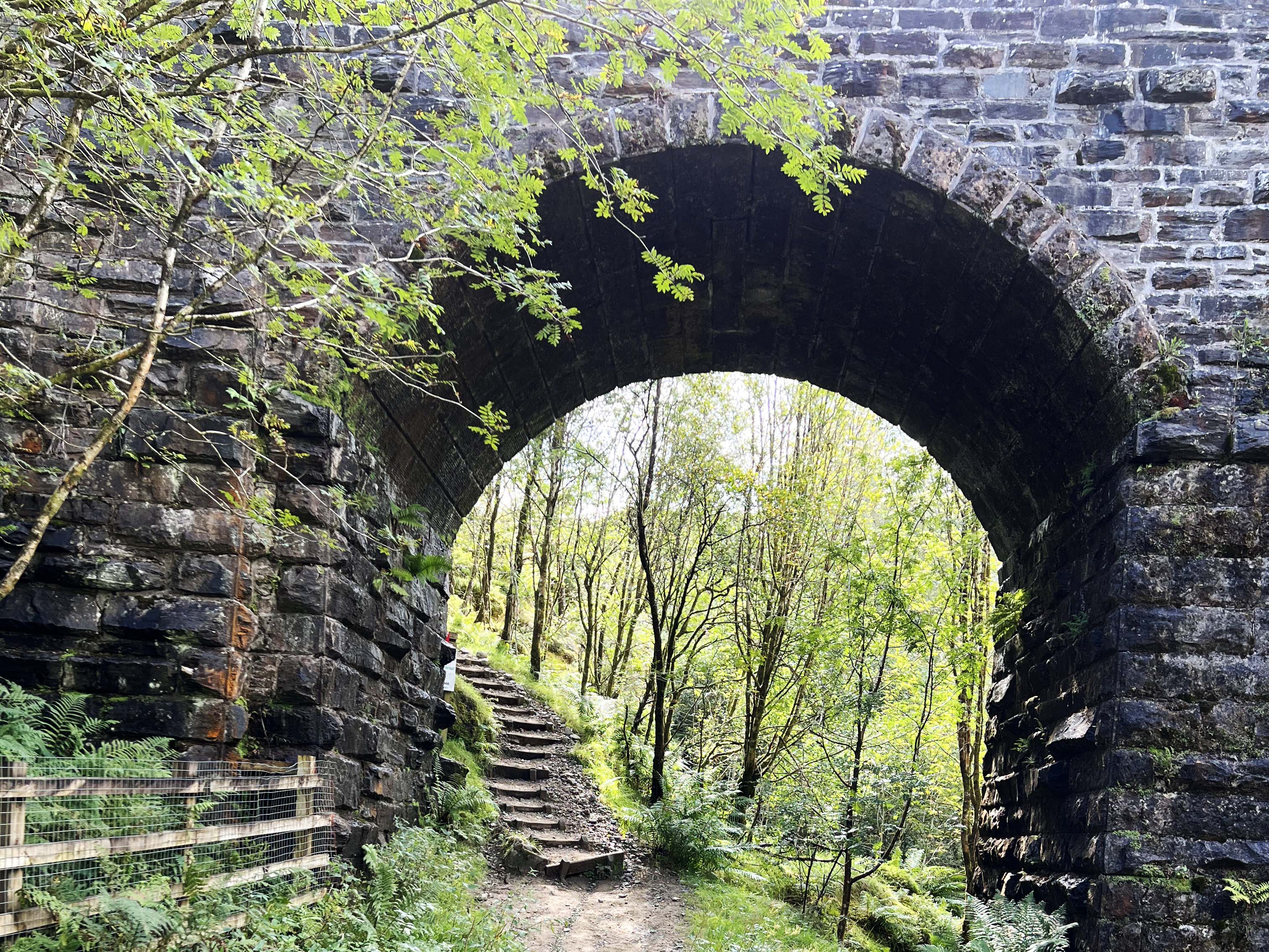 a stone archway over a path